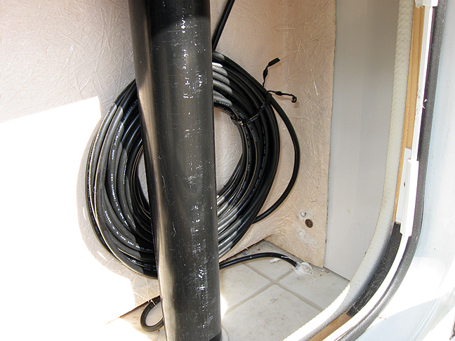 Cable routing in area behind shower stall
