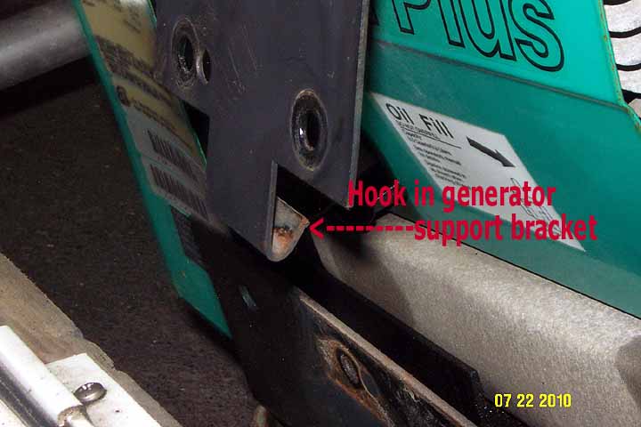 Shows the hook on the bottom of the generator support bracket that must be unhooked by jacking the generator somewhat higher after the removal of the two 1/2&amp;quot; bolts.